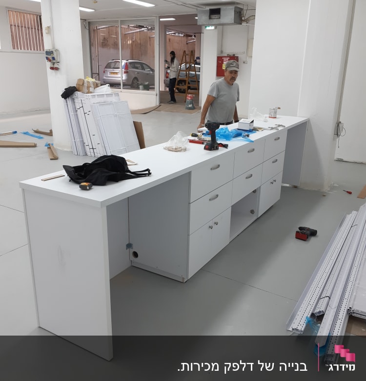 נגר ליד שולחן עבודה עם כלים וחומרים